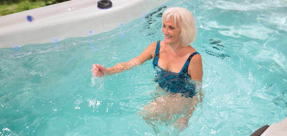 Une dame marchant dans l'eau à contre-courant dans un spa de nage.